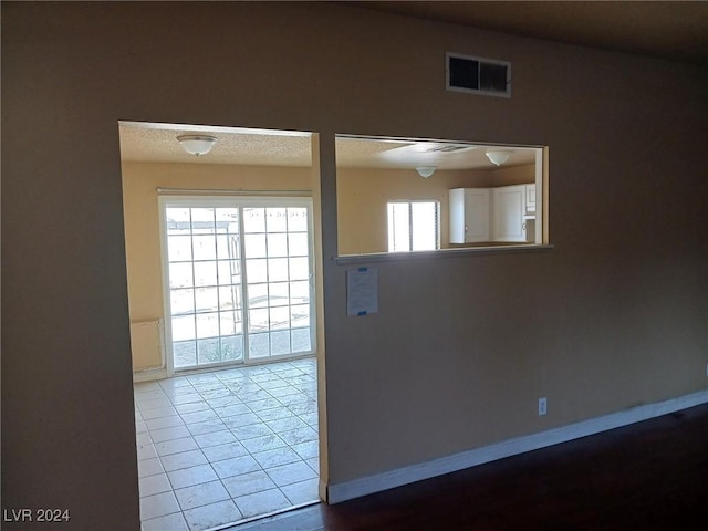 unfurnished room with tile patterned floors and a healthy amount of sunlight