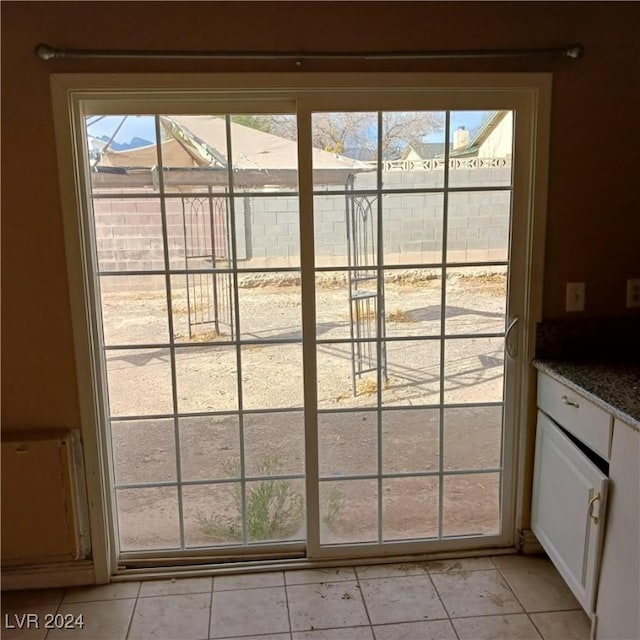 doorway to outside featuring light tile patterned flooring