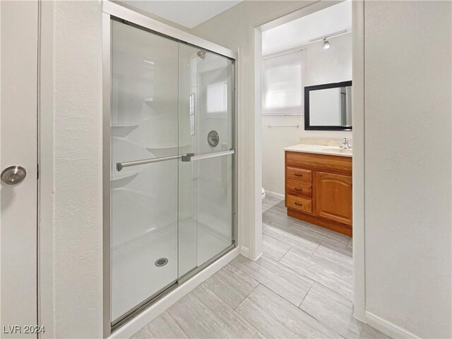 bathroom featuring vanity, toilet, and a shower with door