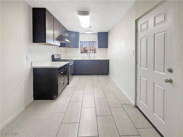 kitchen featuring extractor fan, sink, and stainless steel stove