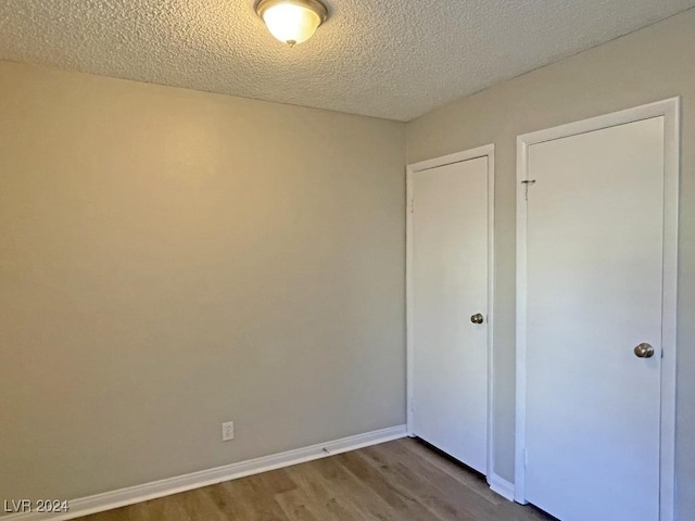 unfurnished bedroom featuring a textured ceiling and hardwood / wood-style flooring