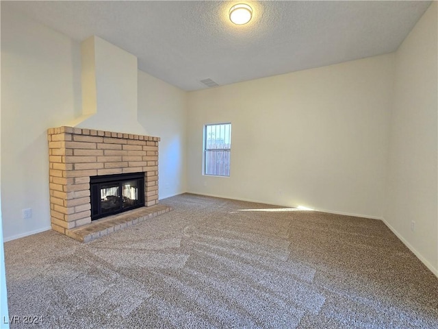 unfurnished living room featuring carpet flooring, a textured ceiling, and a fireplace