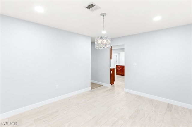 unfurnished room featuring a notable chandelier