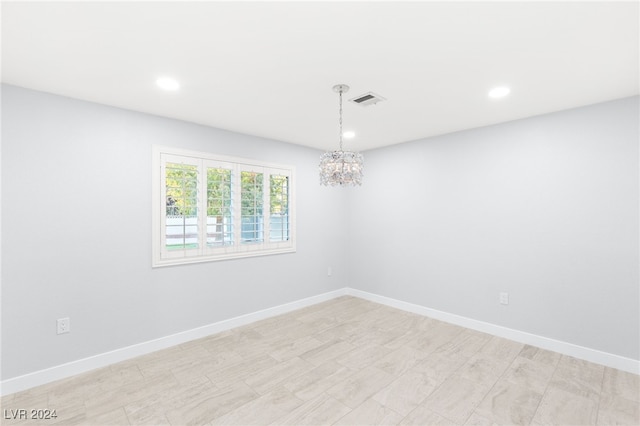 spare room featuring an inviting chandelier