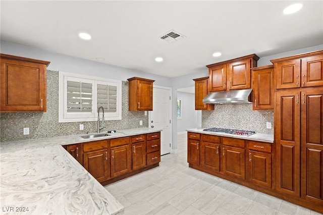 kitchen featuring backsplash, sink, and stainless steel gas cooktop