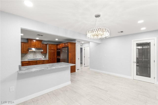 kitchen with pendant lighting, stainless steel fridge, tasteful backsplash, kitchen peninsula, and gas cooktop