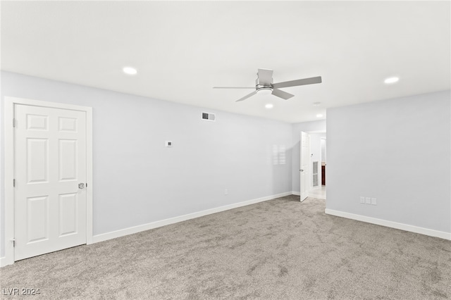 spare room with ceiling fan and light carpet