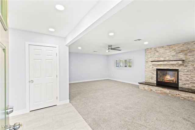 unfurnished living room featuring a fireplace, light carpet, and ceiling fan