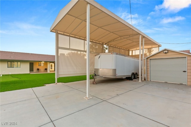 view of patio featuring a garage, a carport, and an outdoor structure