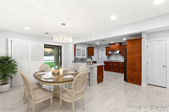 dining space with sink and an inviting chandelier