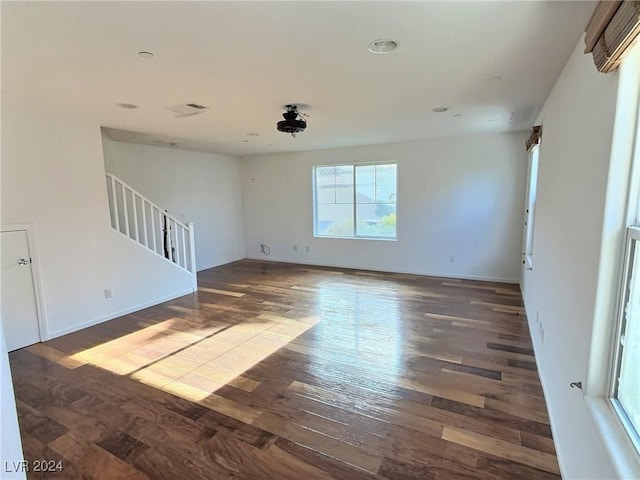 unfurnished room with dark wood-type flooring