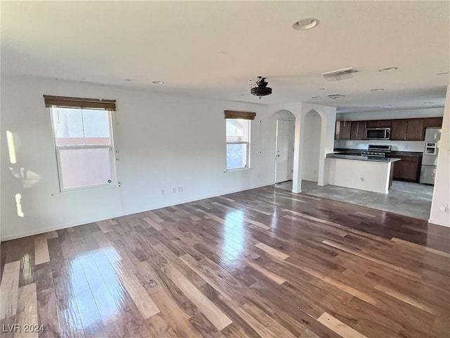 unfurnished living room with hardwood / wood-style floors and a healthy amount of sunlight