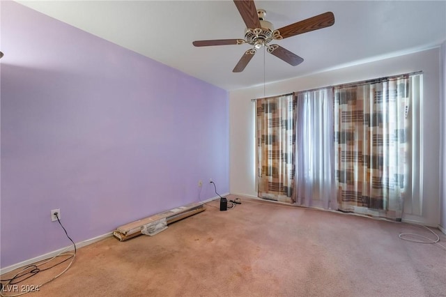 empty room featuring ceiling fan and light carpet