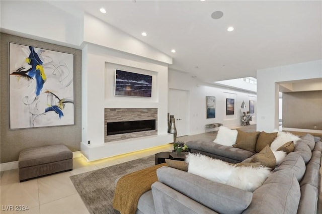 living room with light tile patterned flooring, vaulted ceiling, and a stone fireplace