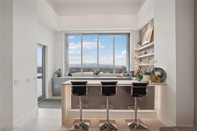 kitchen with a kitchen breakfast bar and light tile patterned flooring