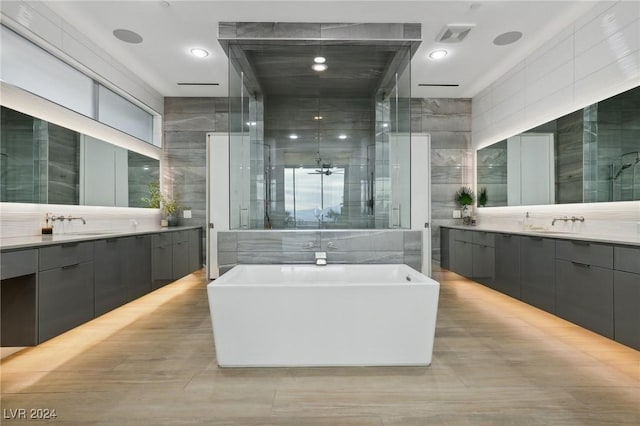 bathroom featuring tile walls, vanity, and independent shower and bath