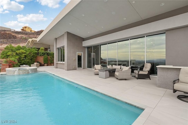 view of pool featuring an in ground hot tub, outdoor lounge area, and a patio area