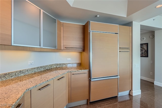 kitchen featuring light brown cabinetry and light stone counters