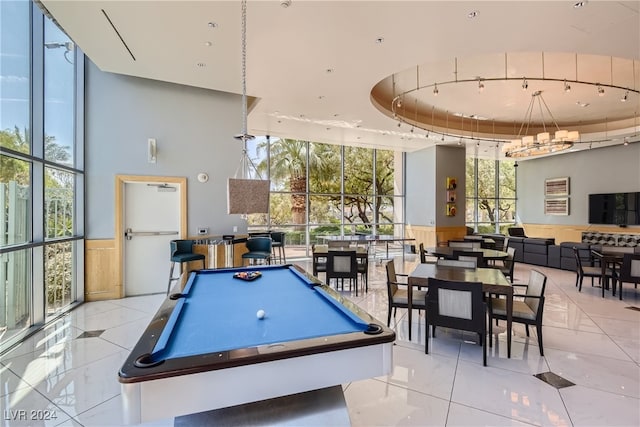 game room featuring a wealth of natural light, billiards, light tile patterned floors, a tray ceiling, and expansive windows