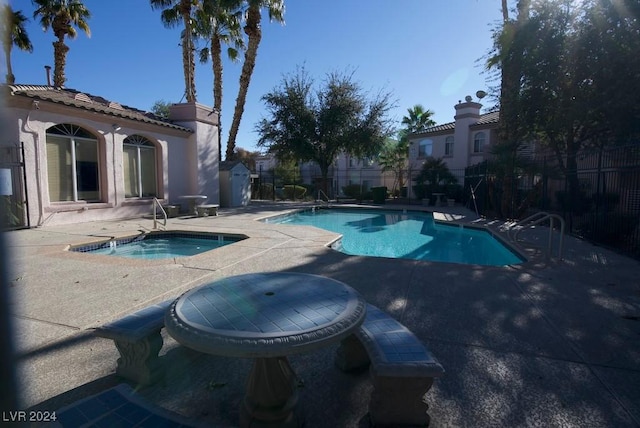 view of pool featuring an in ground hot tub and a patio area