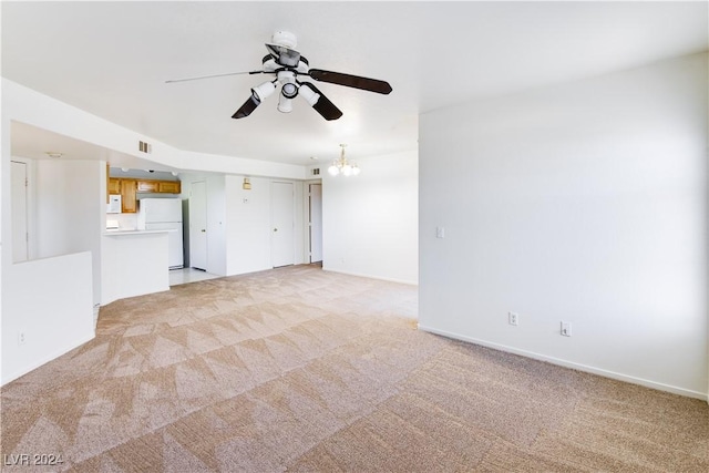 unfurnished living room with ceiling fan with notable chandelier and light colored carpet