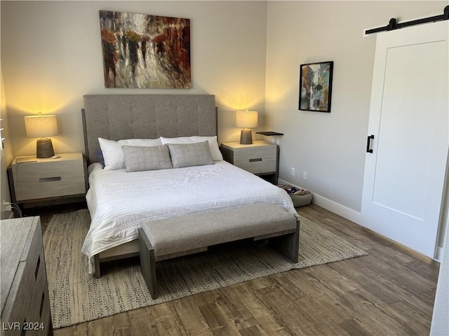 bedroom with hardwood / wood-style floors and a barn door