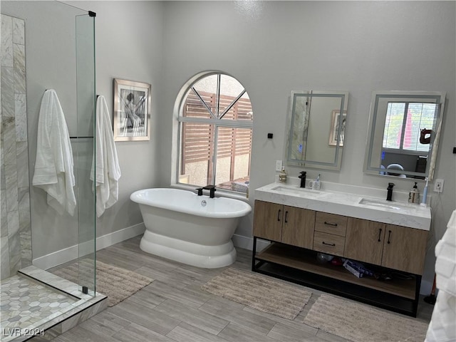 bathroom featuring plus walk in shower, hardwood / wood-style floors, and vanity