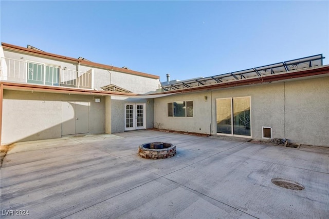 back of property featuring a patio area, an outdoor fire pit, and french doors