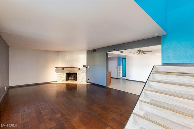 unfurnished living room with hardwood / wood-style flooring, ceiling fan, and a fireplace