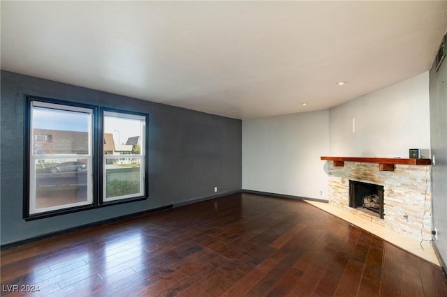 unfurnished living room featuring a fireplace and dark wood-type flooring