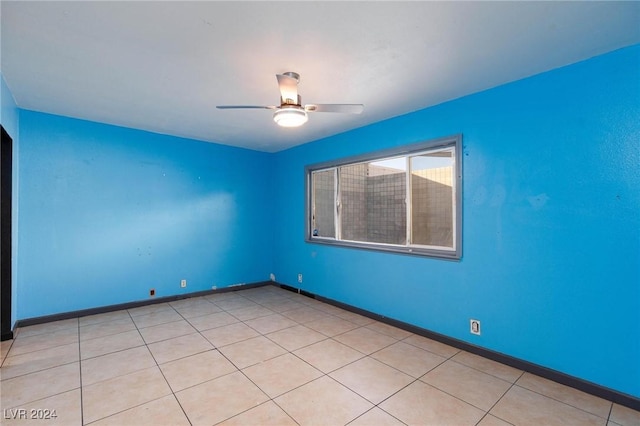 tiled spare room featuring ceiling fan