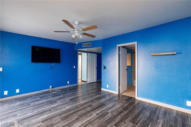 unfurnished bedroom with ceiling fan, ensuite bathroom, and dark wood-type flooring