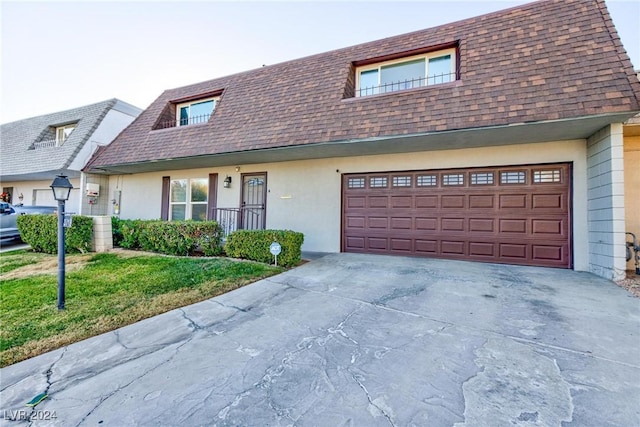 view of front of property with a garage and a front lawn