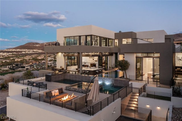 back house at dusk with a mountain view and an outdoor fire pit