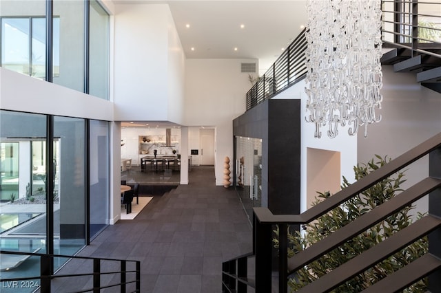 corridor featuring a notable chandelier and a towering ceiling