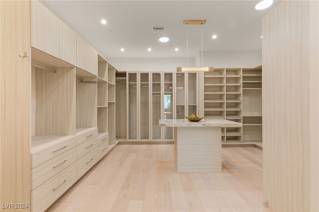 walk in closet with light wood-type flooring