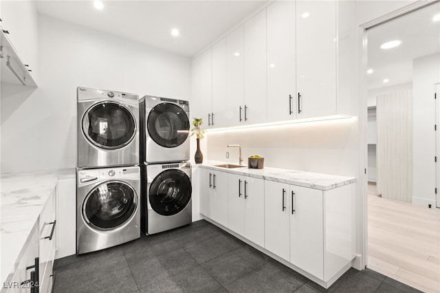 clothes washing area with cabinets, stacked washing maching and dryer, sink, independent washer and dryer, and dark hardwood / wood-style floors