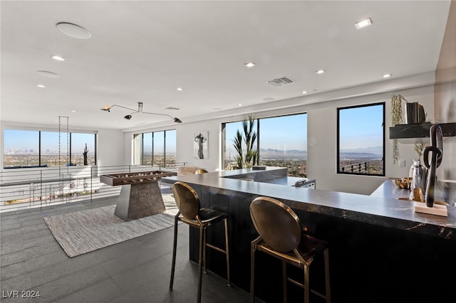 kitchen with a wealth of natural light, a breakfast bar, and hanging light fixtures