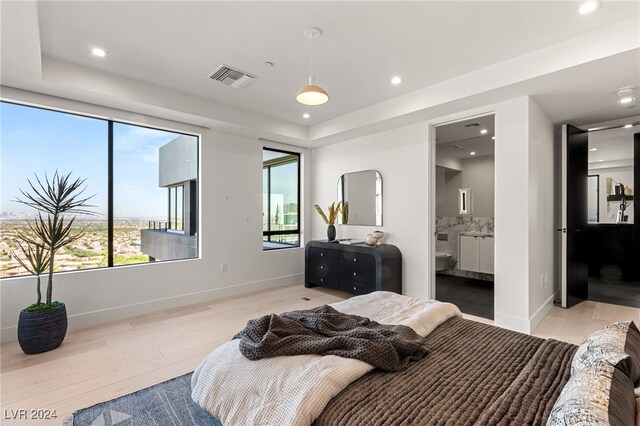 bedroom with light wood-type flooring and ensuite bath