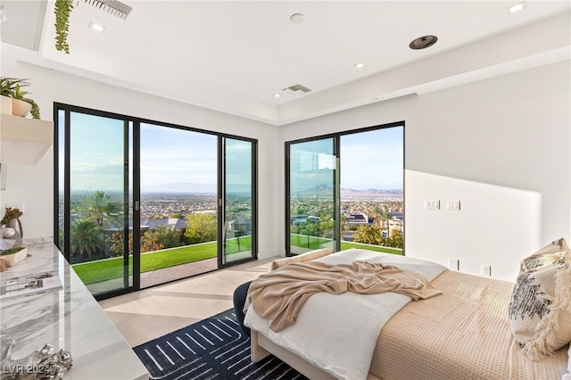 bedroom with access to exterior, light wood-type flooring, and multiple windows