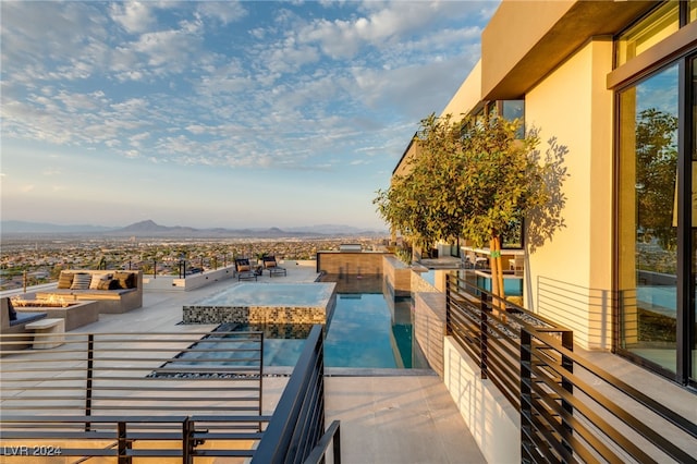 view of swimming pool with a mountain view and a fire pit