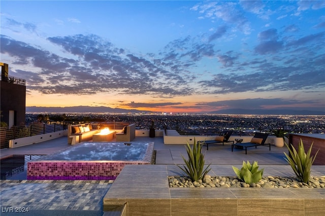 pool at dusk featuring a patio and a fire pit