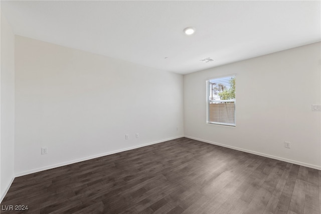 unfurnished room with dark wood-type flooring