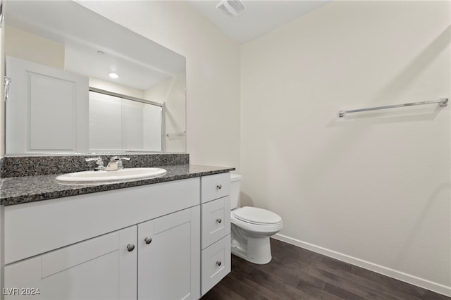 bathroom featuring vanity, hardwood / wood-style flooring, toilet, and an enclosed shower