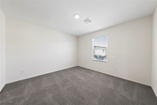 unfurnished room featuring dark carpet