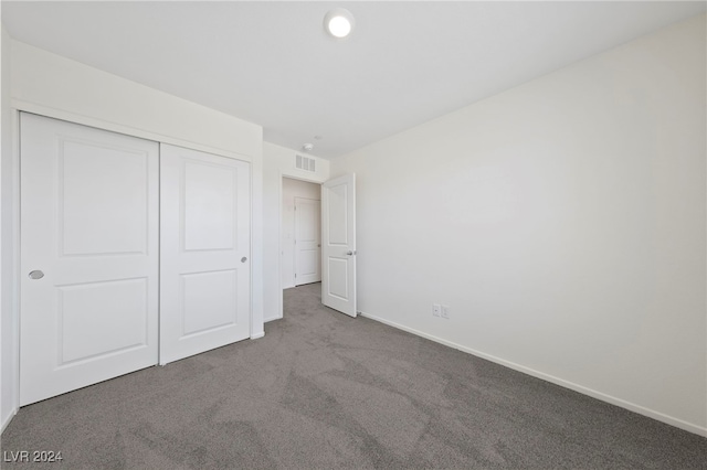 unfurnished bedroom featuring carpet flooring and a closet