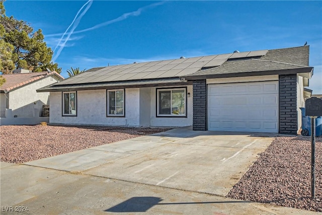 ranch-style home featuring solar panels, covered porch, and a garage