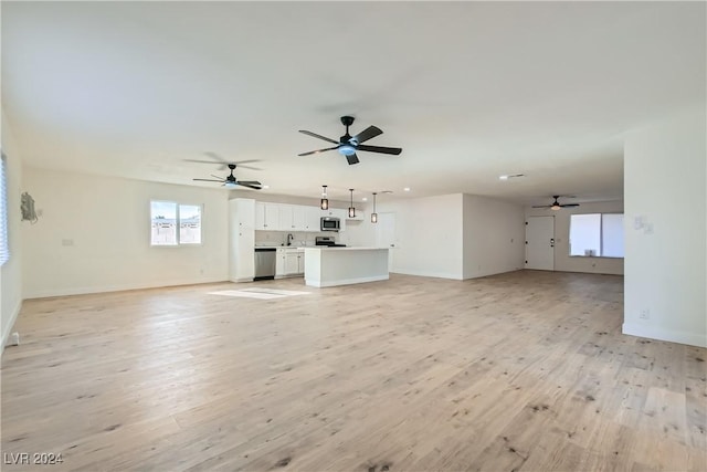 unfurnished living room featuring light wood-type flooring and sink