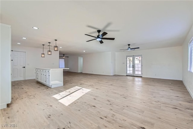 unfurnished living room with ceiling fan, light hardwood / wood-style floors, and french doors