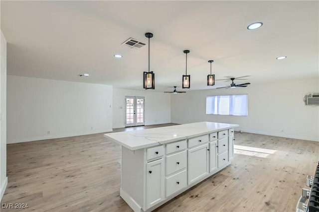 kitchen featuring a wealth of natural light, a center island, white cabinets, and ceiling fan